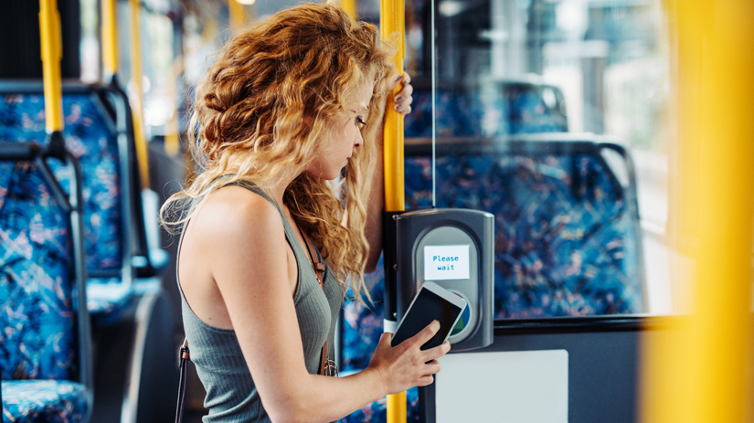 Młoda kobieta dokonuje płatności na urządzeniu samoobsługowym 